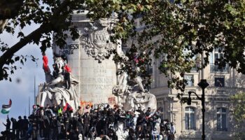 Manifestantes sobre el monumento de la plaza de la República de París durante la protesta del 17 de octubre de 2026